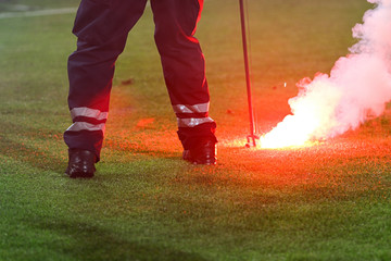 Fireman removing smoke flare from soccer field