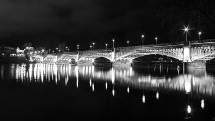 Bridge at night illuminated and reflected in the river