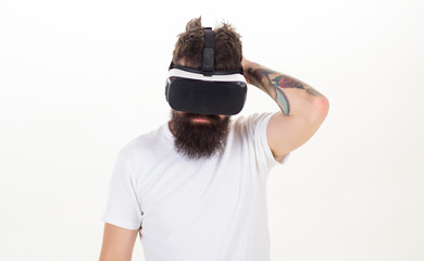 A person in virtual glasses flies in room space. Portrait of bearded male in a white T-shirt with...