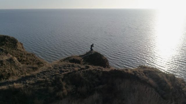 combative sports on nature, strong boy is engaged in wrestling on hill by river in bright sunshine on water against sky before contest