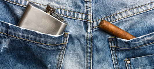 Cigar and alcohol drink in back pocket of pants. Elite alcohol and cigar. Gourmet concept. Habit to...