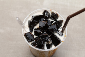 Grass jelly with fresh milk and caramel in plastic cup