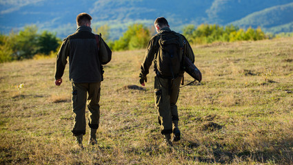Hunters friends gamekeepers walk mountains background. Hunters rifles nature environment. Hunter...