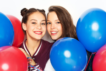 american independence day, holiday and birthday party concept - happy smiling pretty teenage girls with red and blue helium balloons over white background