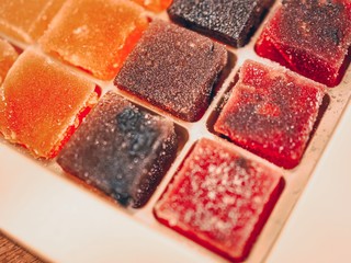 Cubes of jelly of different flavors and colors lie in a box