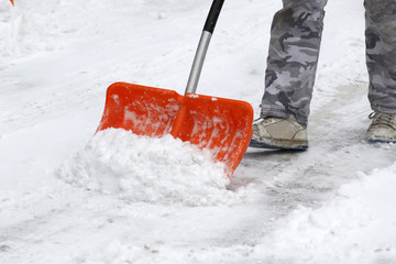 cleaning snow with shovel in winter day