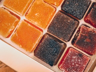 Cubes of jelly of different flavors and colors lie in a box