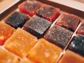 Cubes of jelly of different flavors and colors lie in a box
