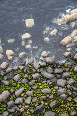 Green stones in water near Kilt Rock, Scotland, UK
