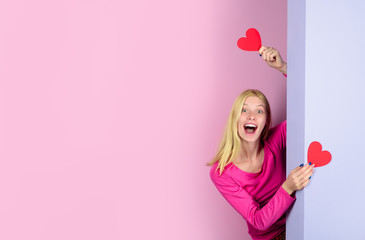 Obraz na płótnie Canvas Valentine's Day. Beautiful woman with two paper hearts in hands. Happy girl on Valentine's day with hearts. Cute cheerful girl holds in hands paper heart. Blonde girl with red heart symbol. Copy space