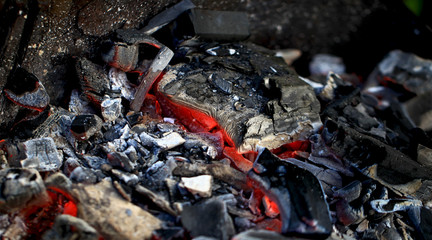 burning coals in the barbecue on a blurred background, the texture of the flame