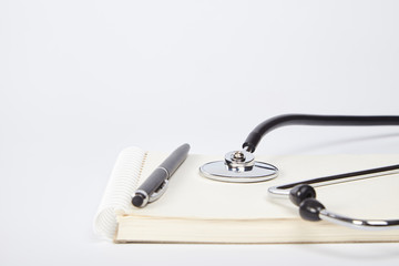  Stethoscope, notebook, pen on white background.  Medical equipment.