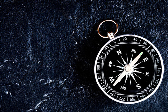 compass on dark background concept - direction motion top view