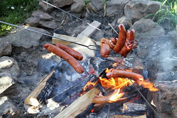 grilling sausages on open fire