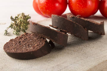 raw irish black pudding on a wooden board