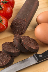 raw irish black pudding on a wooden board