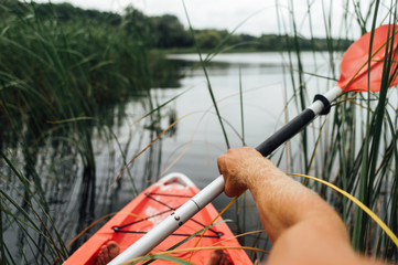 red kayak swimmer on the lake in summer