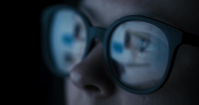Close-up female in glasses reflecting social media browsing