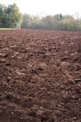 Freshly plowed field in winter season. Rural scene
