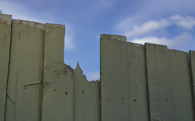 Fototapeta na wymiar Broken wooden fence with blue sky background
