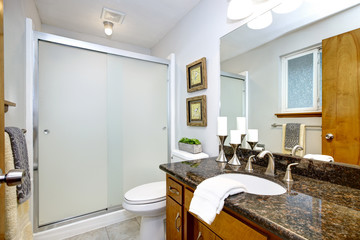 Remodeled bathroom with dark granite counter top vanity