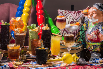 Whiskey-cola cocktail, mojito-cocktail, orange cocktail, strawberry cocktail in glass glasses with straws. Bar accessories: shaker, spoon, spices on a wooden stand