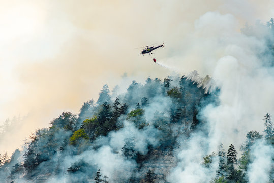 Helicopter Extinguishes Forest Fire On The Slope Of Fuming Mountain