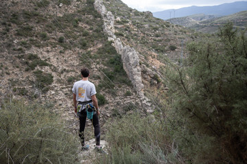 Naklejka na ściany i meble Male climber looking thoughtful to the horizon in a beautiful mountain landscape. 