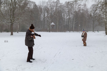Altes Pärchen macht Schneeballschlacht