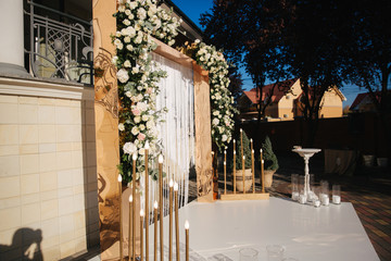 Arch decorated with flowers at the wedding caremony. White and gold color. Rose