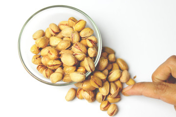 glass of wine filled with salty pistachio nuts on a table