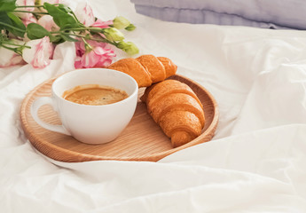 Breakfast in bed with coffee and croissants