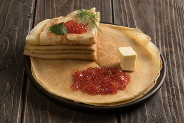 Russian pancakes with red caviar and piece of butter