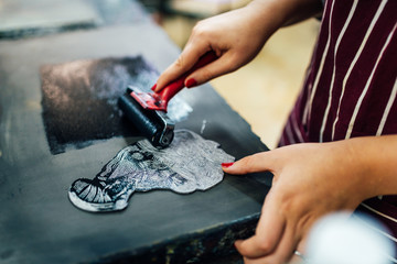 linocut. rolling paint on a piece of linoleum