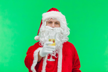 Fototapeta na wymiar Santa holding champagne glass. green background. focus on Santa Claus