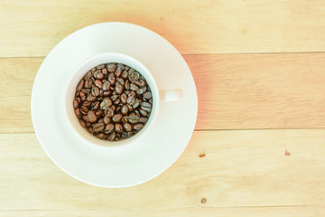 Coffee bean in the cup on wood plate