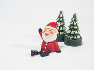 Santa Clause sitting near the green Christmas tree candle waiting for Christmas, happy and prosperity concept