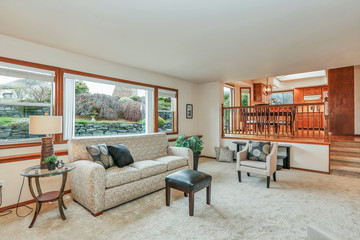 Classic traditional white living room with wood shelves and large windows