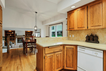Open large kitchen interior with vaulted ceiling and white appliances.