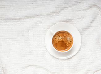 Cup of cofee onthe white knitted background