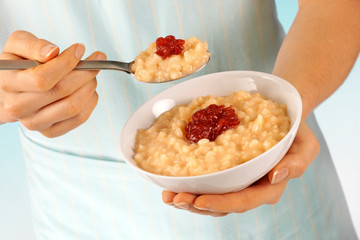 WOMAN EATING RICE PUDDING