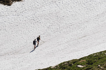 Bergwanderer überquert ein steiles Schneefeld