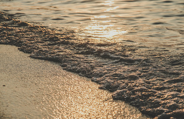 Close up of sea wave sunset or sunrise beach and sand background