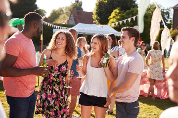 Group Of Friends Enjoying Drinks At Summer Garden Fete