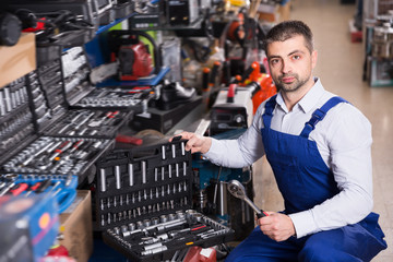 Positive male who is standing near showcase
