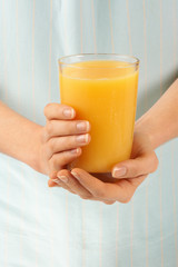 WOMAN HOLDING GLASS OF ORANGE JUICE