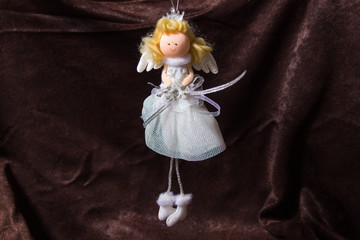 angel doll on a dark brown velvet background