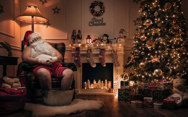 Santa Claus relaxing after or before work in cozy christmas room