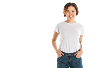 smiling young woman with hands in pockets looking at camera isolated on white