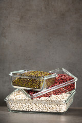 White beans, red beans mung bean in glass bowls on a dark background. Eco friendly, plastic free items.